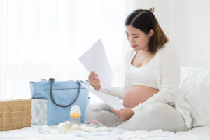 pregnant woman preparing and planning baby products before prenatal